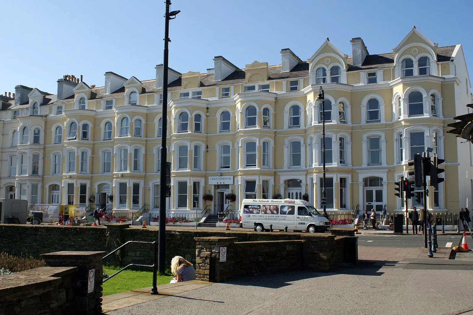 A long cream Victorian terrace on Loch Promenade, Douglas, with the Chesterhouse Hotel sign over the door and a minibus parked outside