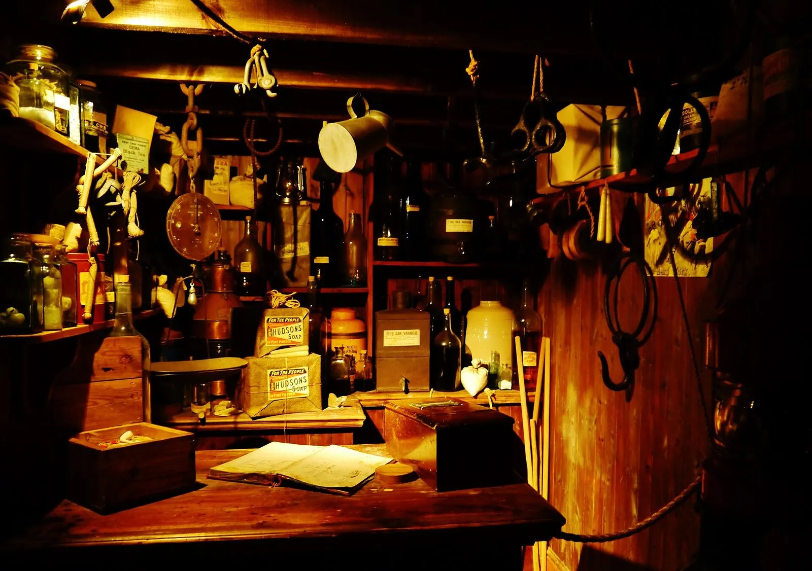 A recreated 19th-century chandler’s shop, with shelves of jars and bottles, soap boxes, weighing scales and ropes lit by a warm lamp