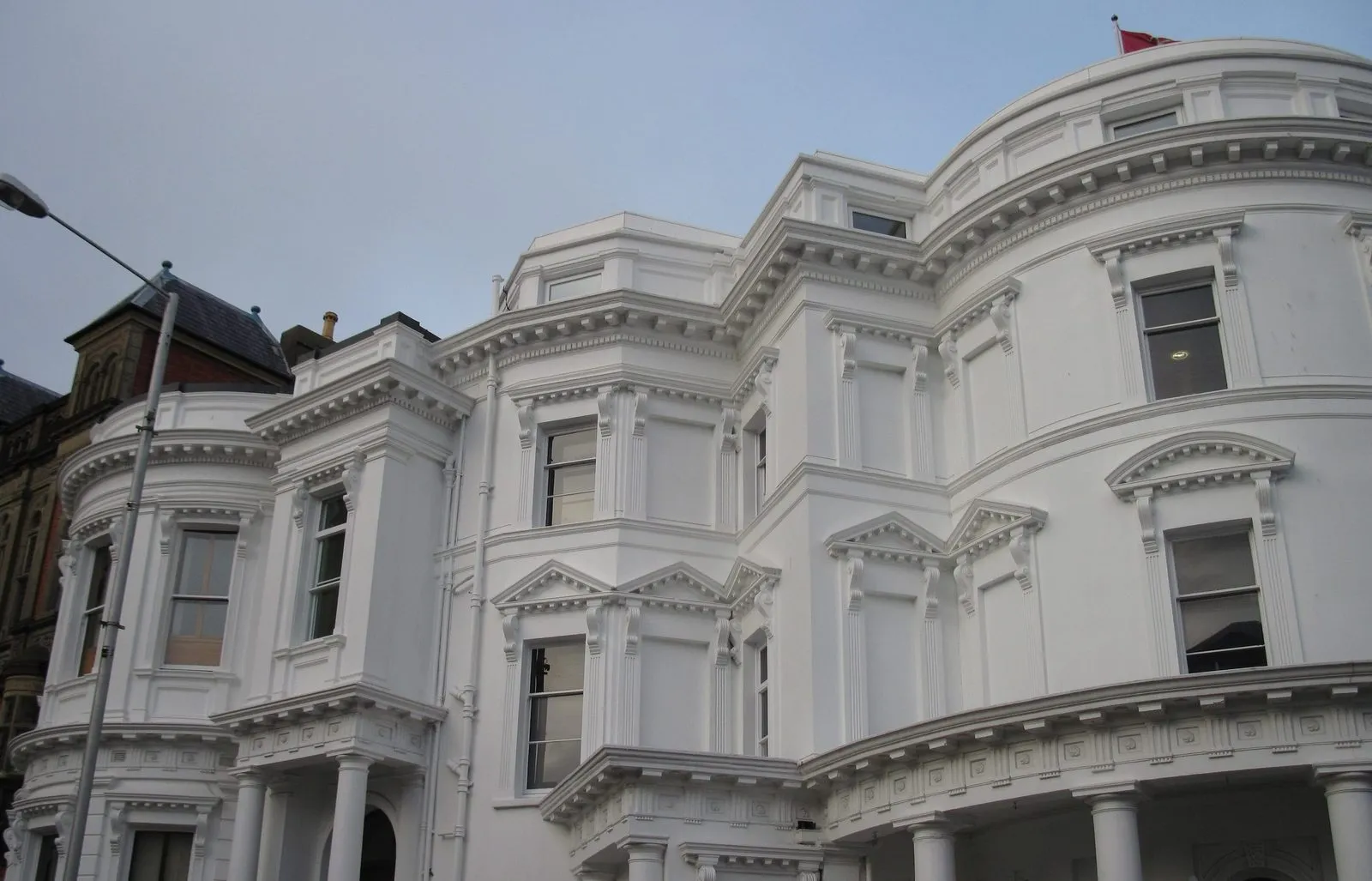 The white, curved front of the Legislative Buildings in Douglas, with the Manx flag on the roof
