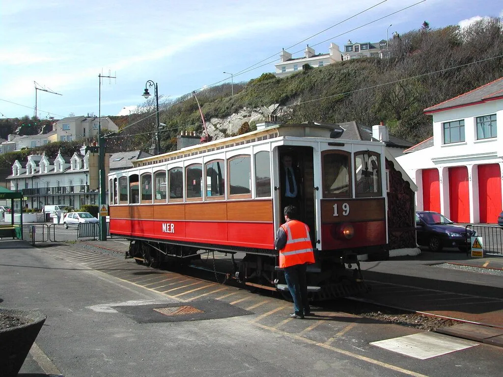 A red and cream Manx Electric Railway tram, number 19, at Derby Castle terminus in Douglas