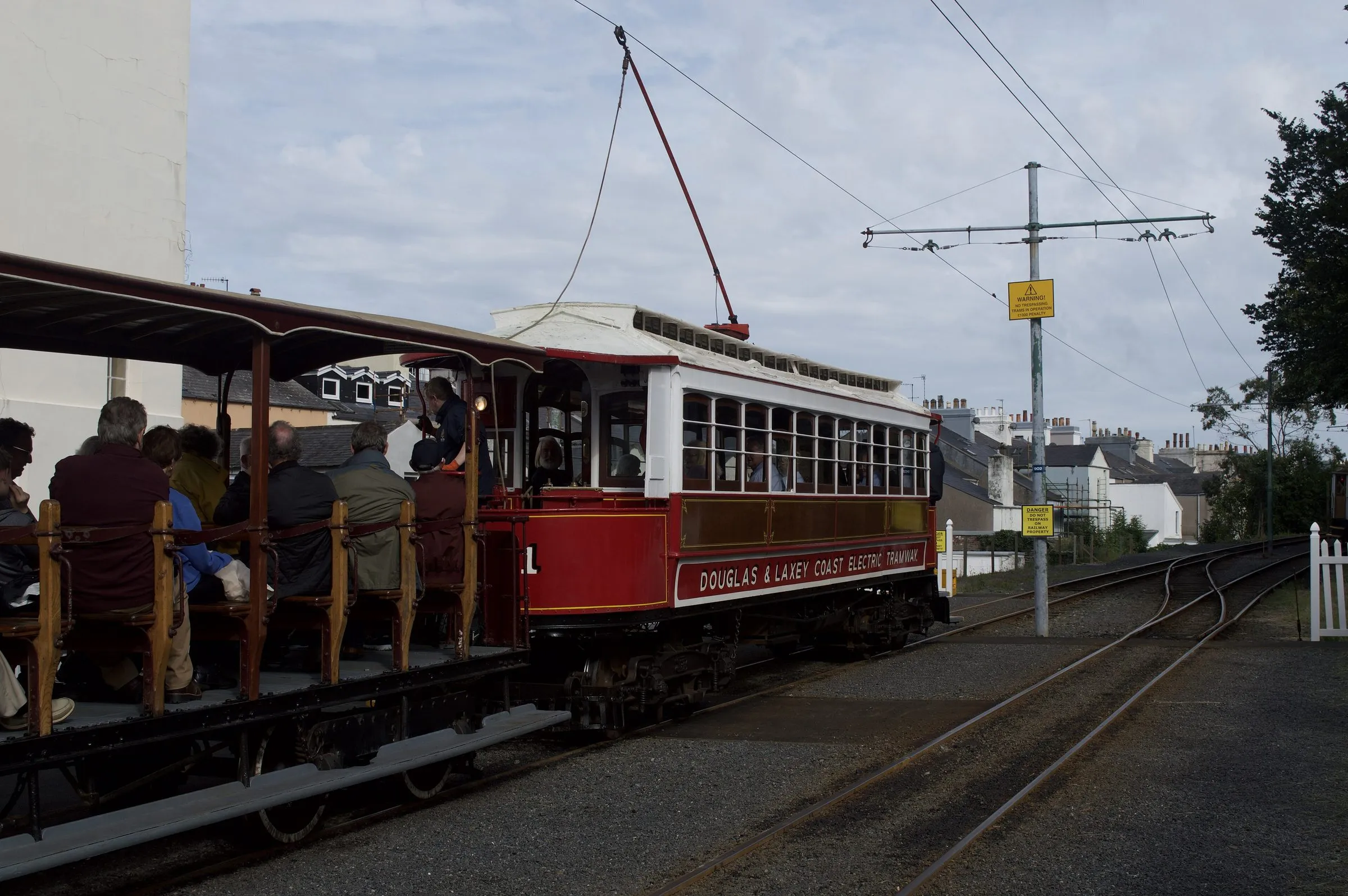 Manx Electric Railway car No. 1, a red and white 1893 tramcar, pulling an open crossbench trailer full of passengers at Ramsey station