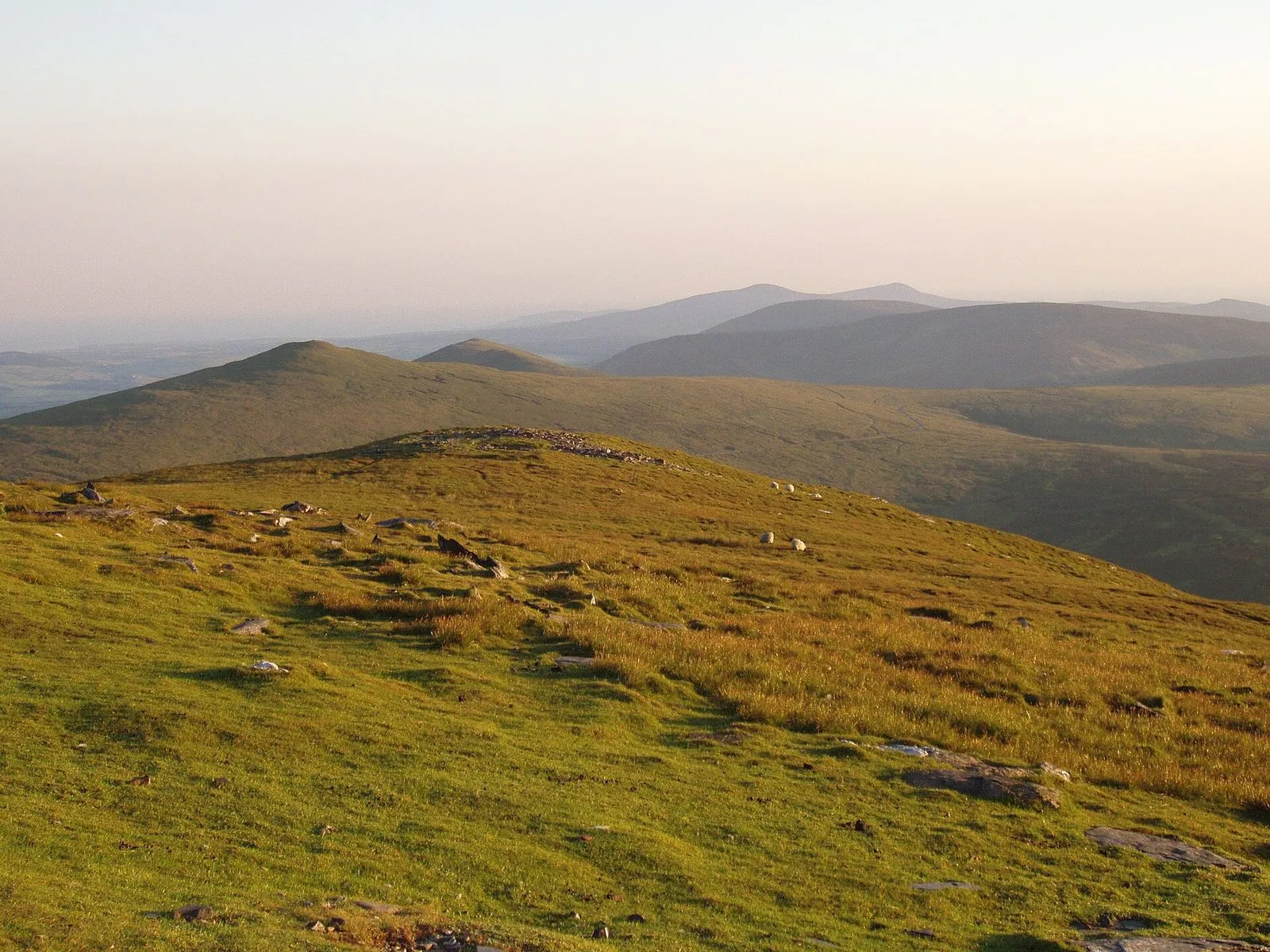 The view from the summit of Snaefell south-west along the island’s spine of rounded green hills, fading into haze