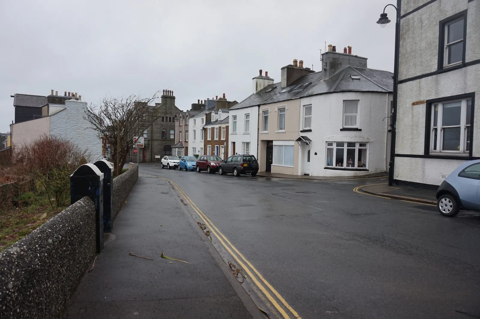 A row of white and cream terraced cottages on a wet day on Primrose Terrace in Port St Mary