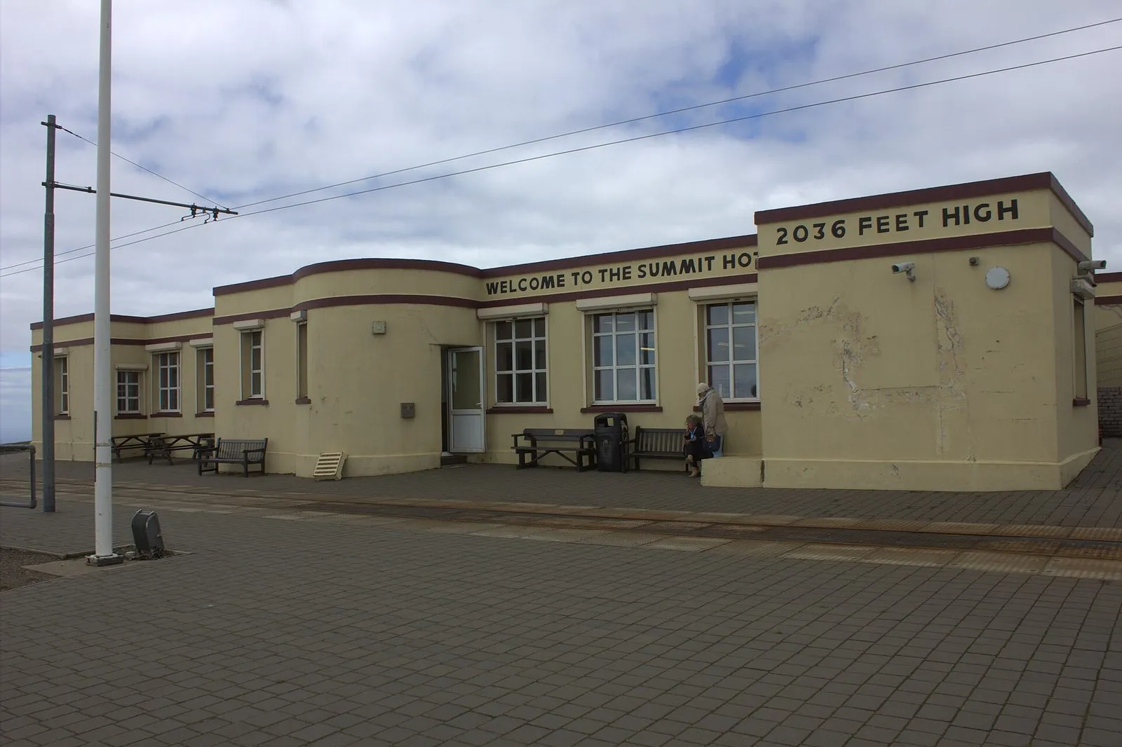 The low cream-coloured Summit Hotel building on Snaefell with “Welcome to the Summit Hotel” and “2036 feet high” painted on it