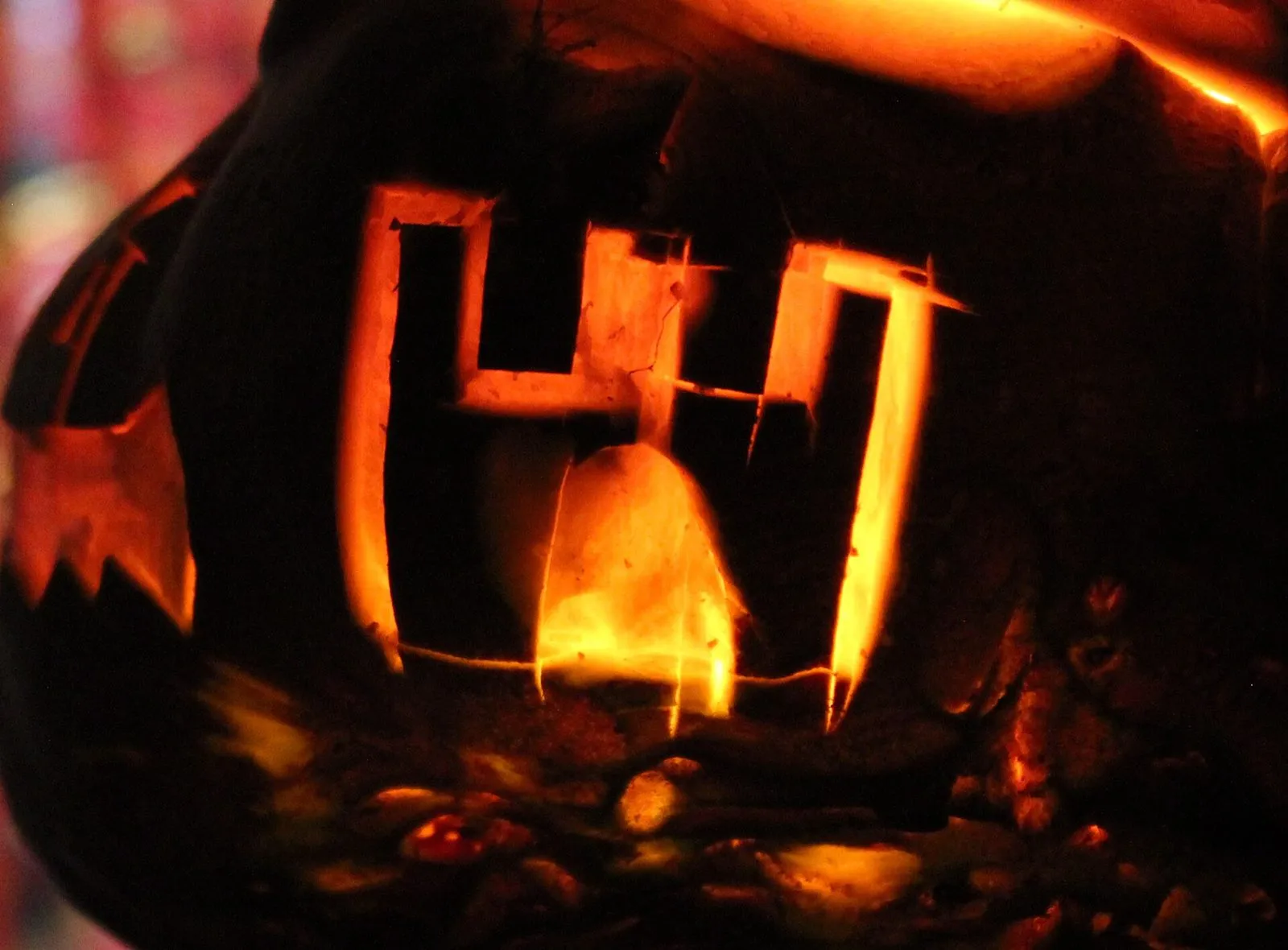 A carved turnip lantern glowing orange in the dark, with a castle cut into its side
